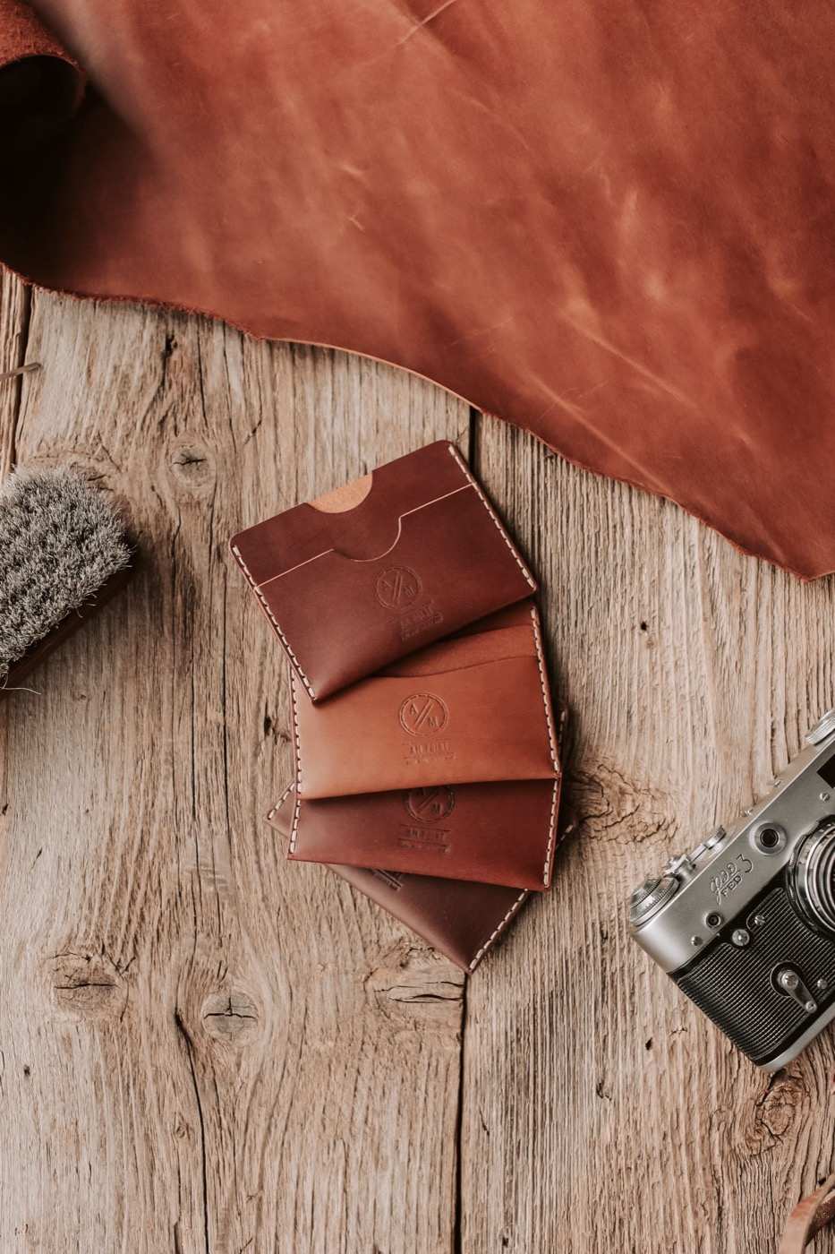 Portacarte in cuoio e una pelle conciata su un tavolo di legno