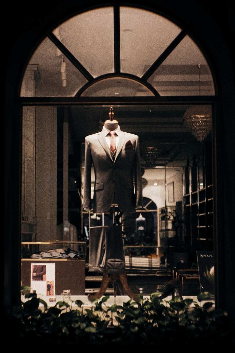 Vetrina ad arco di una sartoria, con un abito grigio su un manichino